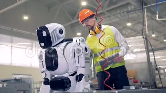 一个男工人打开机器人开始工作视频的预览图