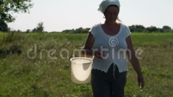 中弹行走中的老村妇女头上有一块木板手里有一只空塑料桶视频的预览图