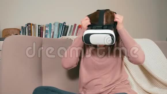 成年女性在家中戴虚拟现实眼镜坐在沙发上视频的预览图