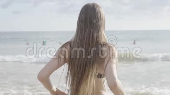 美丽的运动女孩在斯利兰卡海滩漫步在海洋中长发视频的预览图