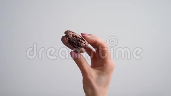 手拿着白色背景的巧克力杏仁饼视频的预览图