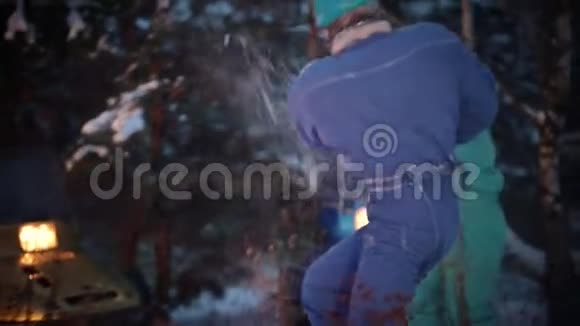 冬季森林一家人在火边的树林里玩雪视频的预览图
