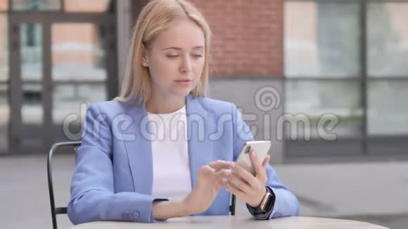年轻女商人在使用智能手机时因损失而烦恼视频的预览图