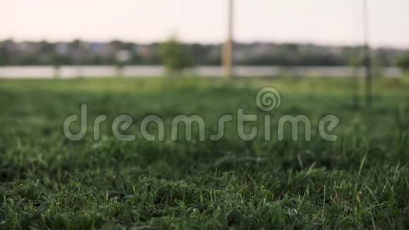花园里绿草如茵背景中有割草机的人走近了视频的预览图