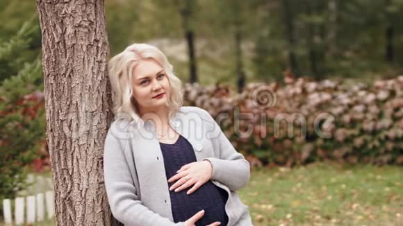 HD孕妇站在树旁边视频的预览图