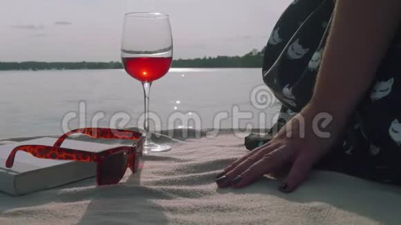 一杯红酒太阳镜书和女孩的手拿着它喝了之后把它盖上视频的预览图