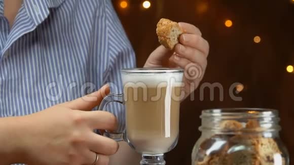 手拿脆饼把它灌入咖啡中视频的预览图