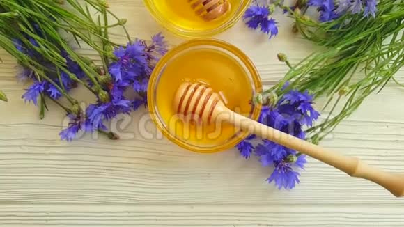 新鲜蜂蜜矢车菊甜点天然木质背景夏季慢动作视频的预览图