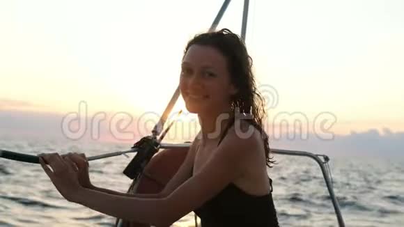 在游艇上穿着泳装在日落时欣赏海景的幸福女人的肖像视频的预览图
