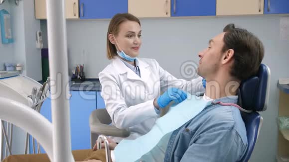 女性牙医开始检查男性病人视频的预览图