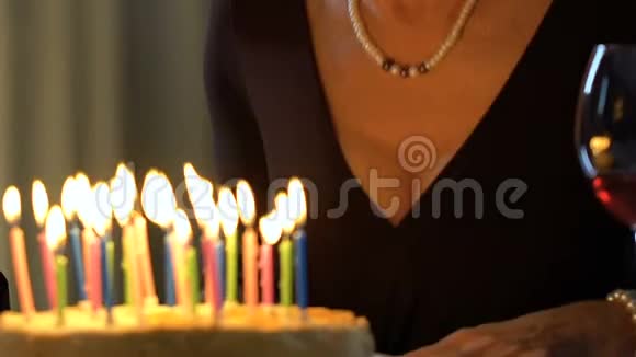 老妇人在蛋糕上吹蜡烛生日纪念日惊喜视频的预览图