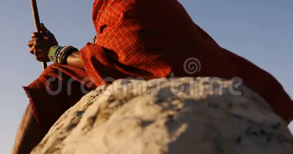 部落男人在岩石上放松视频的预览图