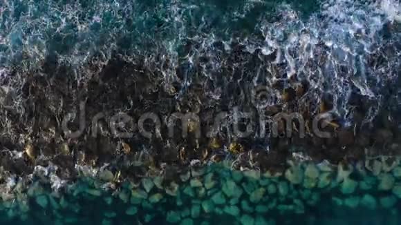 靠近海岸的大西洋表面的俯视图波浪在防波堤上滚动岛屿海岸视频的预览图