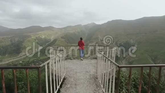 站在观景台上的妇女可以看到峡谷山峰悬崖的山谷景色视频的预览图