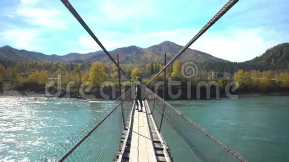 旅行者的女人把牧师带到山河悬桥上阿尔泰山视频的预览图