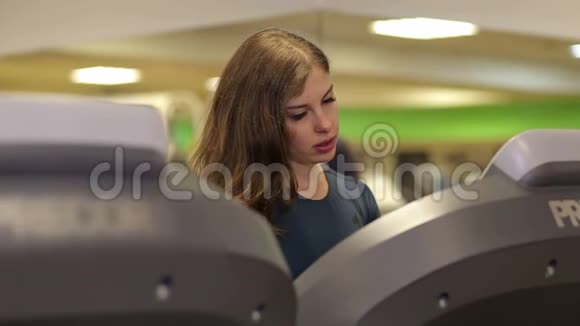 女孩在健身房的跑步机上跑步它反映在镜子里视频的预览图