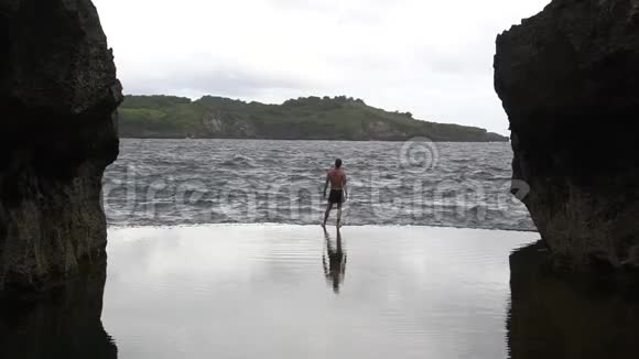 一个人手举在一个自然的水池里背景是海洋天使斯比拉邦努沙佩尼达印度尼西亚视频的预览图