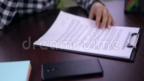 妇女阅读并签署就业申请假签名视频的预览图