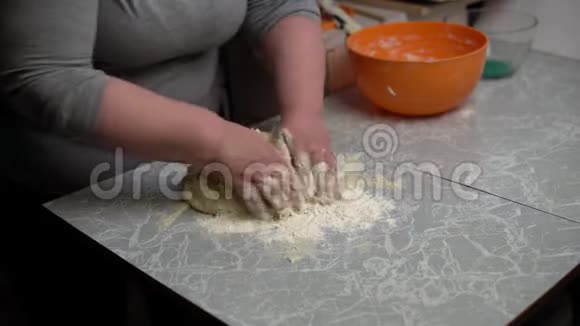 双手捏着厨房桌上的面团视频的预览图