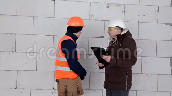 工程师和建筑师讨论项目计划他们头上戴着防护头盔工作项目视频的预览图