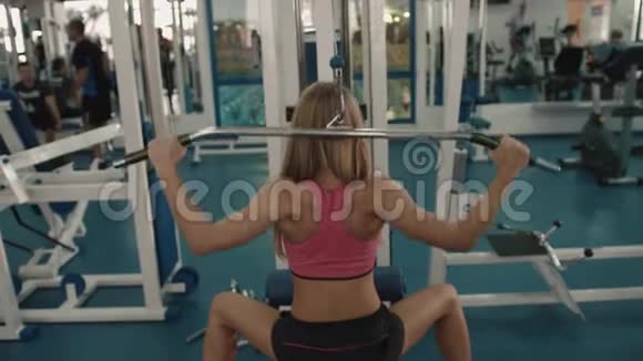 运动的金发女运动员在健身站上打铁的时候她的后视角暖和了起来4k视频的预览图
