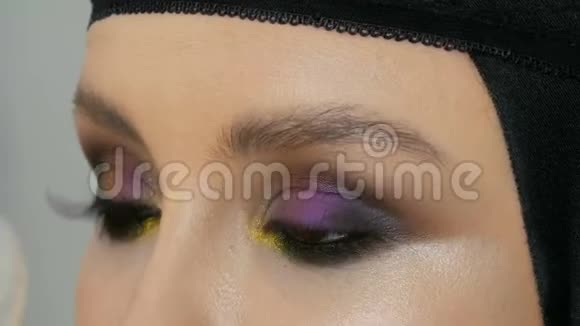 美丽女孩眼睑上的黄色紫色灰色银色的时尚多色眼影变色龙视频的预览图