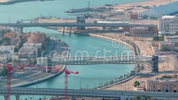 日落时分迪拜的水上运河带有人行天桥从市中心的摩天大楼屋顶空中穿越视频的预览图
