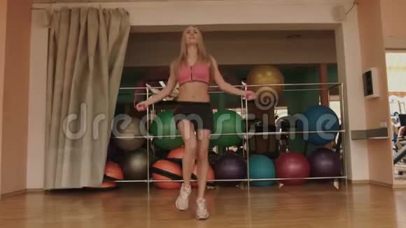 身材瘦削的漂亮运动女人正在健身房跳绳4k视频的预览图