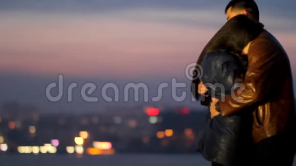 一个男人在夜城的背景下拥抱一个女孩视频的预览图