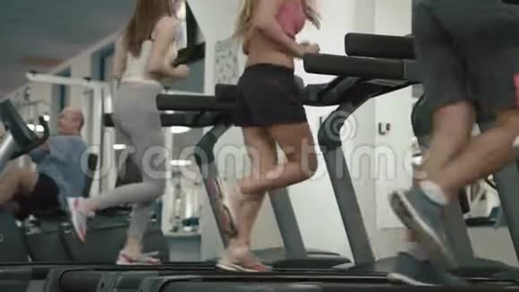 运动战中的无名运动员们正在跑步机上跑步以此来热身4K录像没有脸健身房的位置视频的预览图