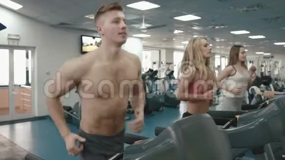 健身房的人三个健康和运动的朋友正在跑步机上跑步4K录像视频的预览图