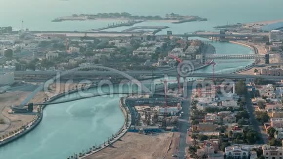 日落时分迪拜的水上运河带有人行天桥从市中心的摩天大楼屋顶空中穿越视频的预览图