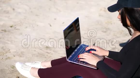 夏天海边日出戴着黑帽子的美女布莱瑟在用笔记本电脑视频的预览图