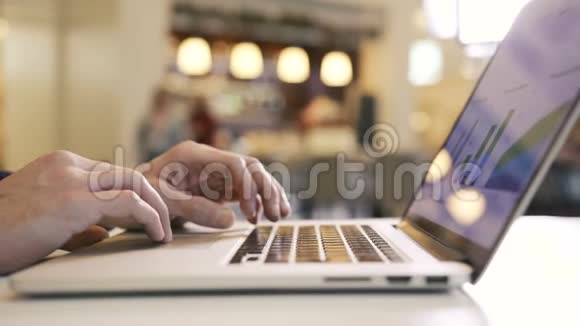 人手工作在笔记本电脑分析图表和图形和手指打字键视频的预览图