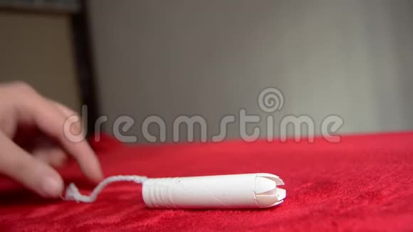 从红色毛毯中取出卫生棉的女人手PMS概念视频的预览图