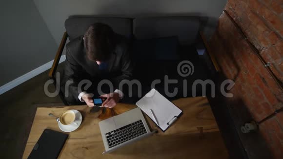 商人在咖啡馆谈论智能手机并与商业文件合作男人坐在咖啡馆的桌子旁在牢房里说话视频的预览图