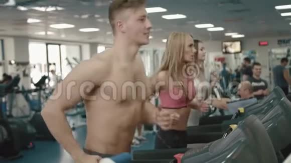 运动与健康生活方式理念肌肉发达英俊的男人和两个活泼迷人的女人正在奔跑视频的预览图