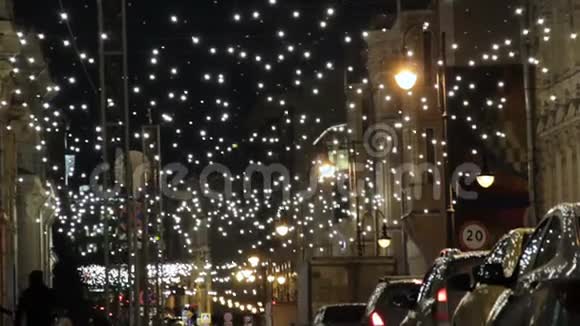 莫斯科市中心的彼得罗夫卡街上装饰着圣诞假日的花环小灯交通堵塞出租车视频的预览图