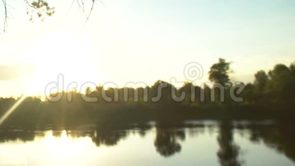 男性背包客在森林里徒步旅行在湖边拍摄美丽的日落视频的预览图