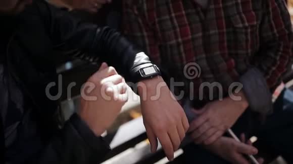 一个男人在一个秋天的公园里在一个年迈的父亲的陪伴下使用一只智能手表视频的预览图
