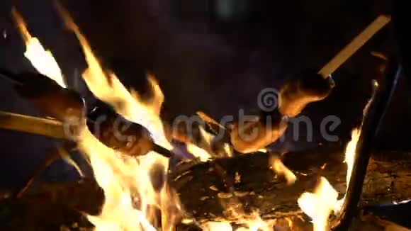 在篝火上炸油条的香肠野火的危险人们在户外做饭视频的预览图