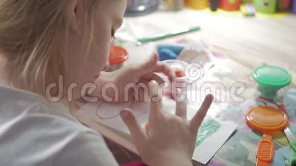 女孩用粘土塑造在家里用粘土雕刻的孩子视频的预览图
