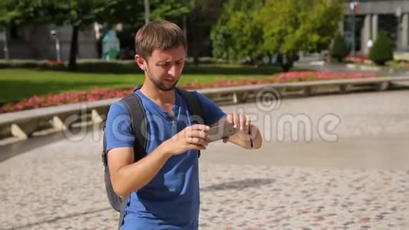 男性旅行者用小玩意拍摄城市景观全景照片暑假视频的预览图