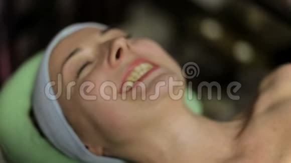 医生把热巧克力放在女孩身体上在水疗中心按摩视频的预览图