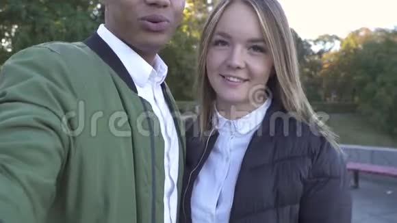 微笑的跨种族夫妇在镜头上拍摄自己视频的预览图