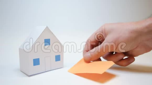 手在纸房旁休息买房子象征着一个橙色的柱子视频的预览图