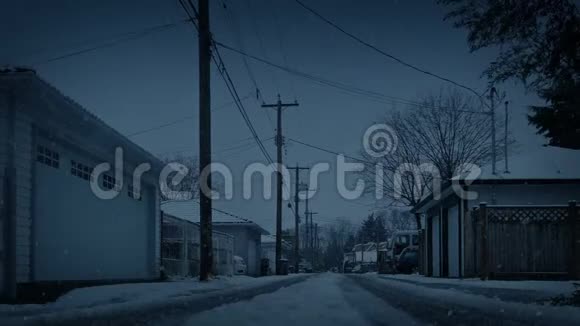 傍晚时分在房屋之间的道路上降雪视频的预览图