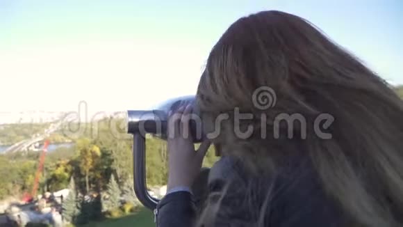 女人用望远镜观看城市景观视频的预览图