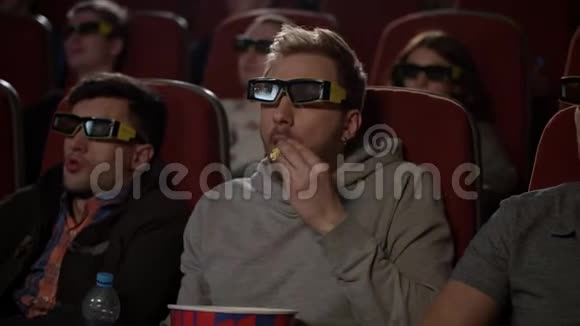 电影院里戴3D眼镜的人三杯酒的男人吃爆米花视频的预览图