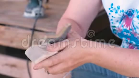 木匠用砂纸打磨一个木制零件特写双手视频的预览图